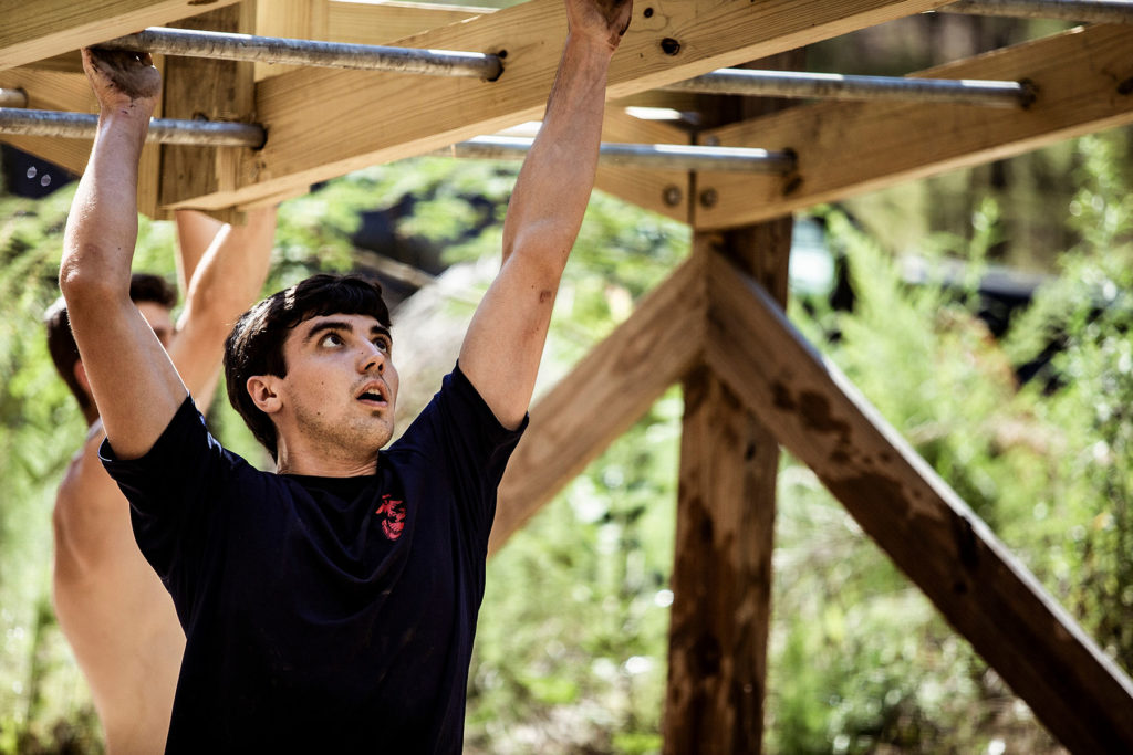 a man standing next to a wooden fence